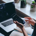 freelancer analyzing payment fees and currency exchange costs on laptop