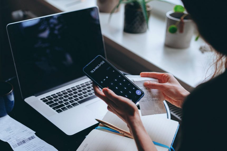 freelancer analyzing payment fees and currency exchange costs on laptop