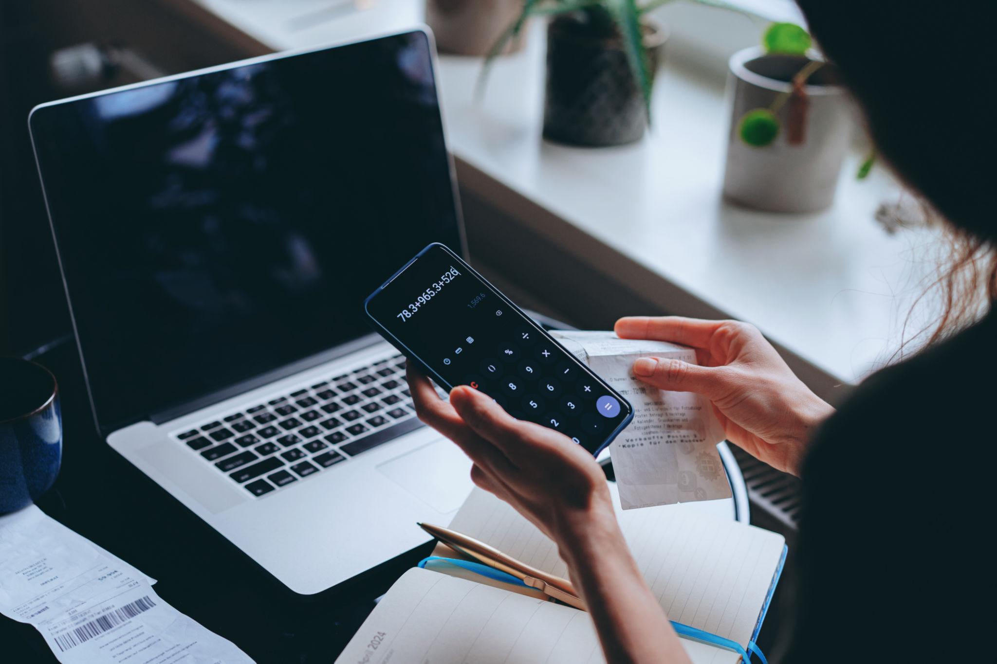 freelancer analyzing payment fees and currency exchange costs on laptop