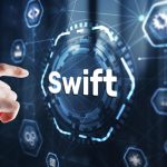 freelancer analyzing international bank transfer fees and SWIFT payments on laptop