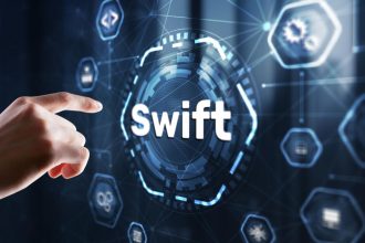 freelancer analyzing international bank transfer fees and SWIFT payments on laptop
