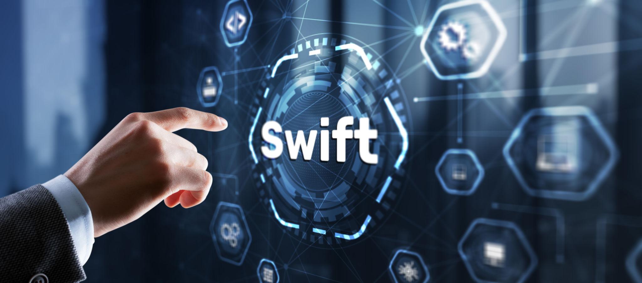 freelancer analyzing international bank transfer fees and SWIFT payments on laptop